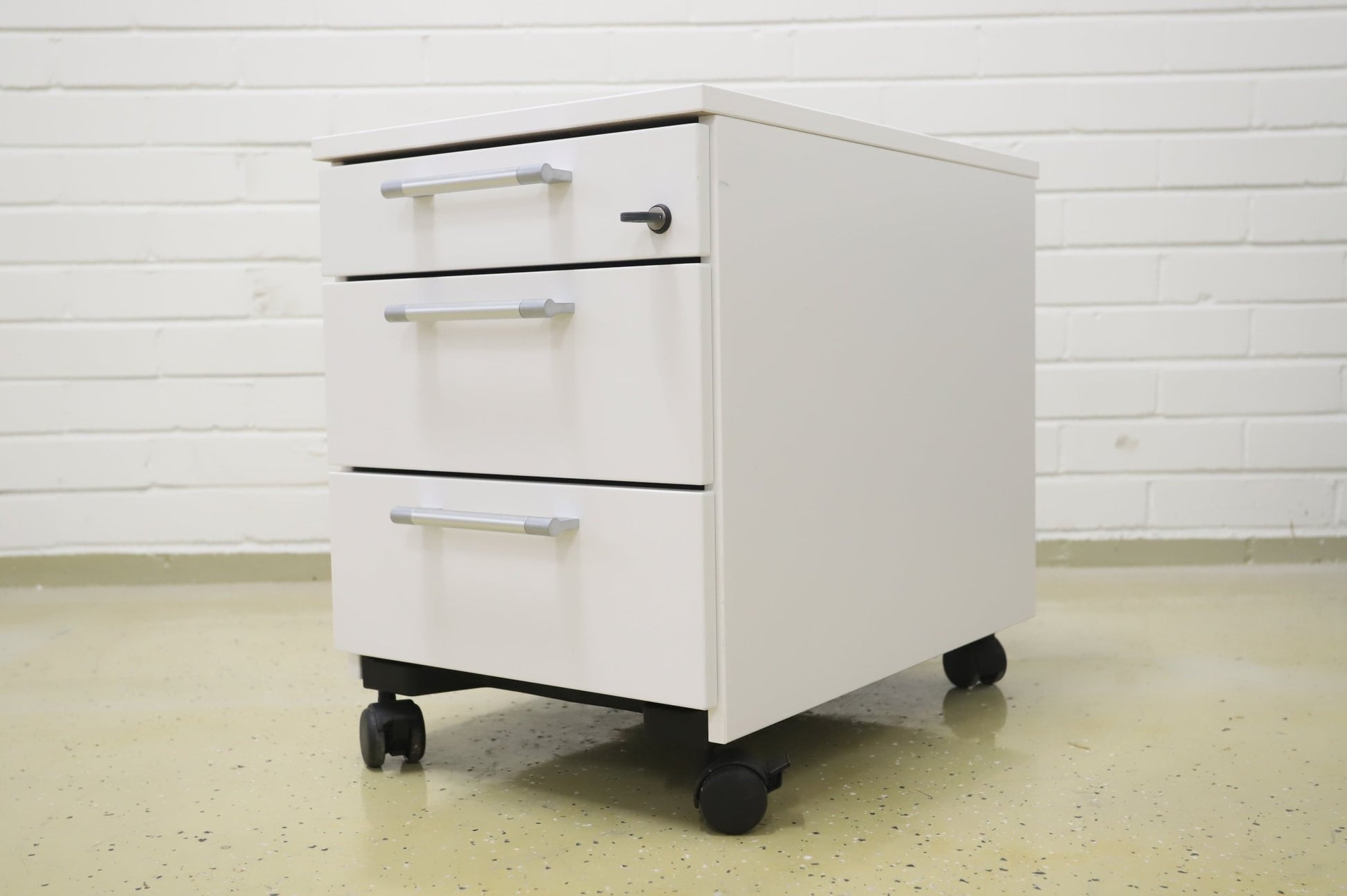 Lukittava kolmeosainen valkoinen laatikosto, harmaat kahvat - Suomen Kalustekeskus