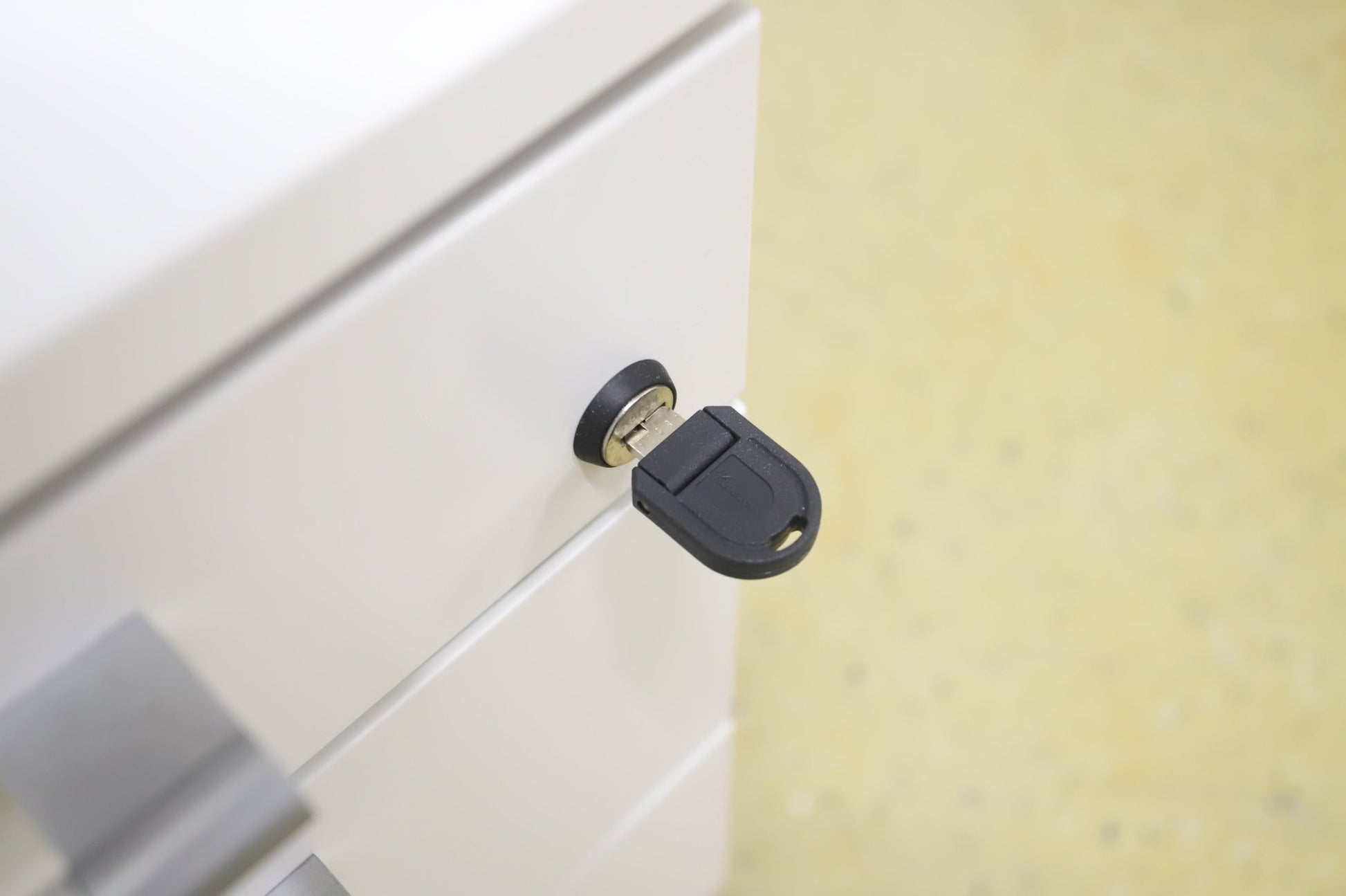 Lukittava kolmeosainen valkoinen laatikosto, harmaat kahvat - Suomen Kalustekeskus