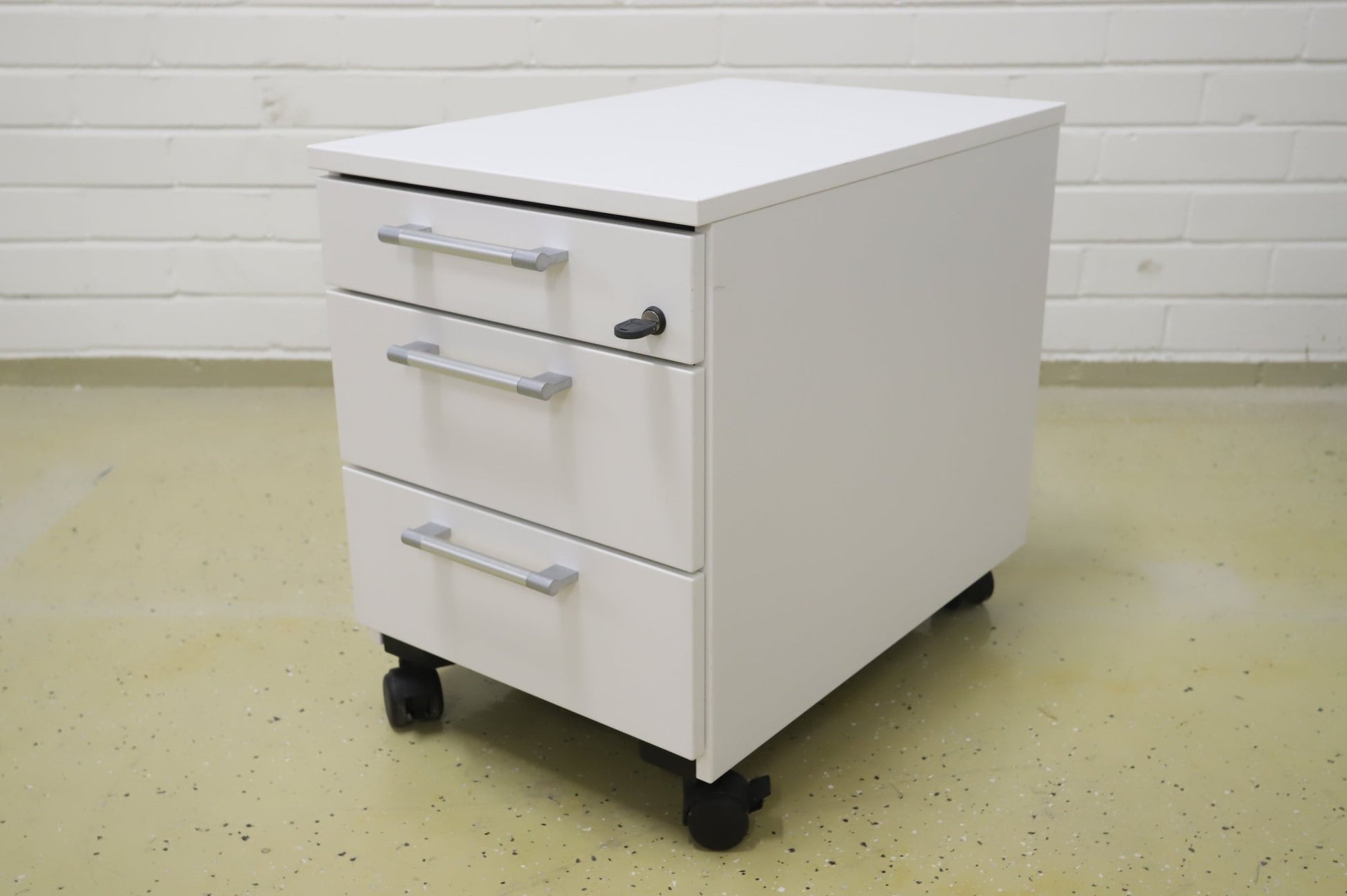 Lukittava kolmeosainen valkoinen laatikosto, harmaat kahvat - Suomen Kalustekeskus