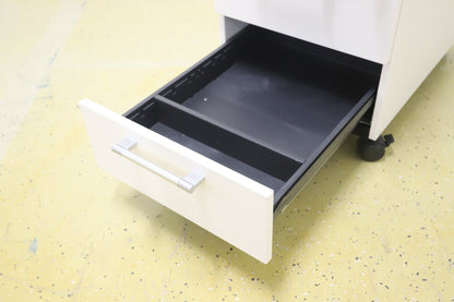 Lukittava kolmeosainen valkoinen laatikosto, harmaat kahvat - Suomen Kalustekeskus