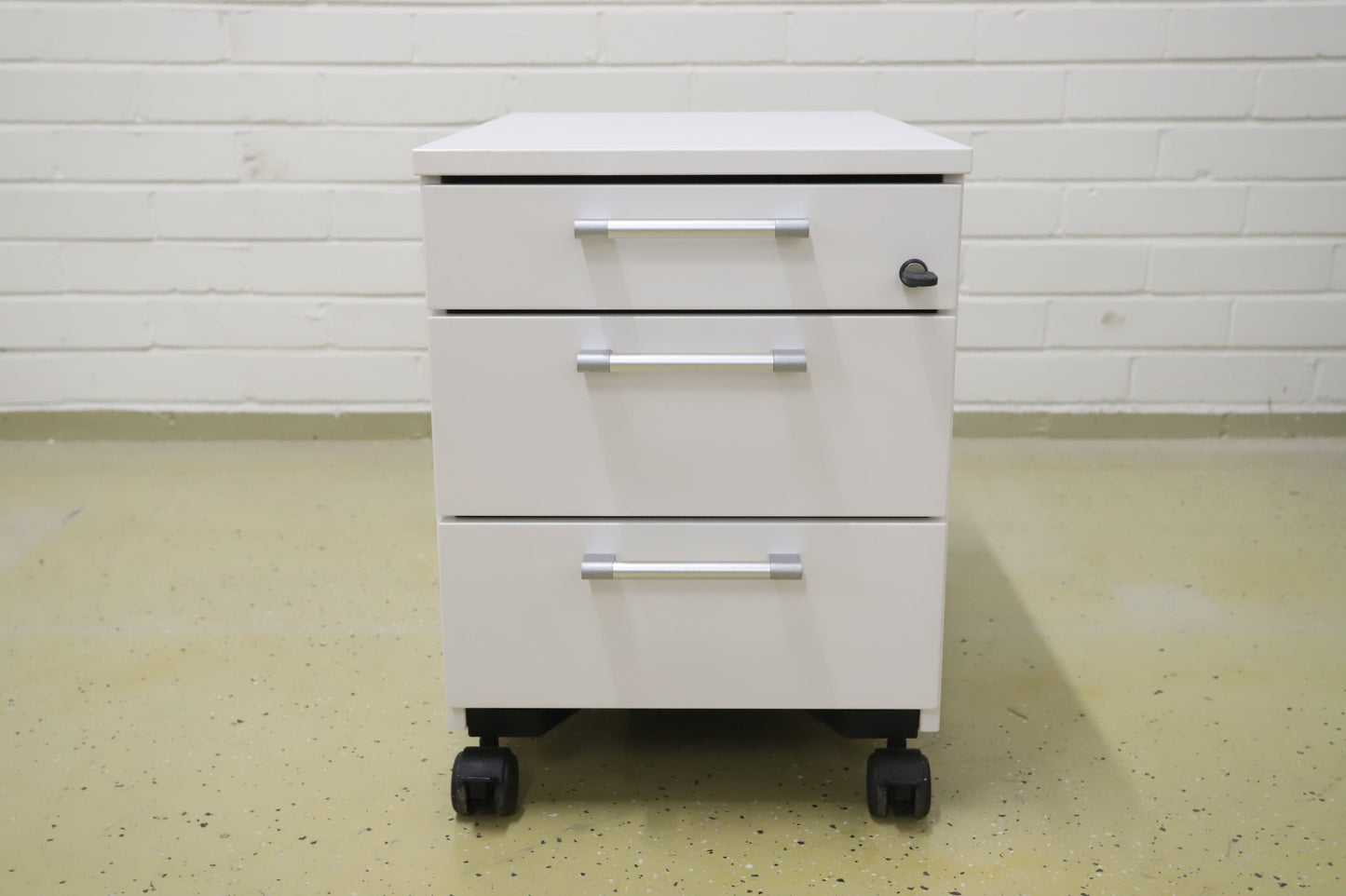 Lukittava kolmeosainen valkoinen laatikosto, harmaat kahvat - Suomen Kalustekeskus