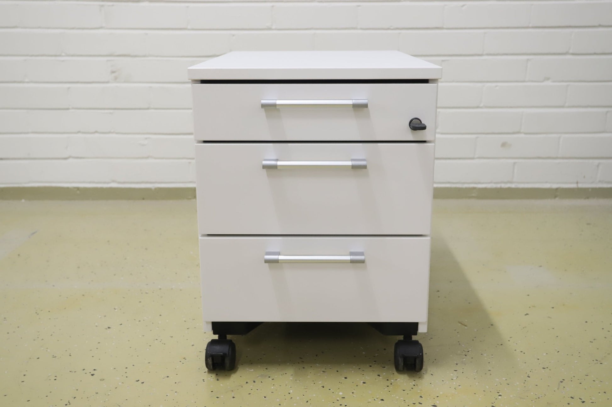 Lukittava kolmeosainen valkoinen laatikosto, harmaat kahvat - Suomen Kalustekeskus